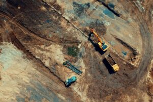 Aerial view of a construction site featuring heavy machinery and trucks, displaying industrial activity.